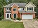 Charming two-story brick home with attached two car garage and lush front yard at 1430 Watercove Ln, Lawrenceville, GA 30043