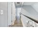 Upstairs hallway with neutral paint, wood-look floors and a metal and white painted wood banister at 1430 Watercove Ln, Lawrenceville, GA 30043