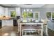 Eat-in kitchen featuring white cabinets, stainless steel appliances, island and backyard views at 1430 Watercove Ln, Lawrenceville, GA 30043