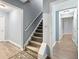 Carpeted staircase with gray walls, white trim and a view into a room with luxury vinyl plank flooring at 1430 Watercove Ln, Lawrenceville, GA 30043
