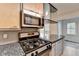 Updated kitchen features stainless steel appliances, gray backsplash, granite counters, and light wood cabinets at 1830 Jan Hill Ne Ln, Atlanta, GA 30329
