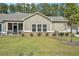 Back exterior featuring a well-maintained lawn, green trees, and screened-in porch at 3901 Shelleydale Dr, Powder Springs, GA 30127