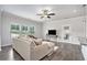Bright living room features a comfortable sectional couch, ceiling fan and hardwood floors at 3901 Shelleydale Dr, Powder Springs, GA 30127