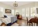 This well-lit bedroom features classic details and ample natural light from large shuttered windows at 9229 Selborne Ln, Chattahoochee Hills, GA 30268