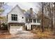 Stunning white two-story home boasts a metal roof, brick chimney, and a convenient attached two-car garage at 9229 Selborne Ln, Chattahoochee Hills, GA 30268