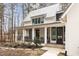 Charming front porch with white columns and black-framed windows with wooded view at 9229 Selborne Ln, Chattahoochee Hills, GA 30268