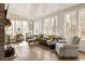 Sunlit living room with cozy seating, a brick fireplace, and hardwood floors creating an inviting space at 9229 Selborne Ln, Chattahoochee Hills, GA 30268