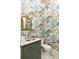 This stylish powder room features a unique wallpaper design, marble countertop and gold mirror at 9229 Selborne Ln, Chattahoochee Hills, GA 30268
