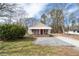 Inviting single-story home with a classic covered front porch, complemented by a gravel driveway and front lawn at 3160 New Macland Rd, Powder Springs, GA 30127