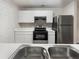 Kitchen with stainless steel appliances, white cabinets, and modern countertops, offering a clean and functional cooking space at 18201 Waldrop Cv, Decatur, GA 30034