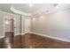 Bedroom showcasing hardwood floors, neutral paint, tray ceiling, and access to hallway and closets at 313 Linda Dr, Tucker, GA 30084