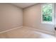 Cozy carpeted bedroom featuring a window offering natural light and serene outdoor views at 313 Linda Dr, Tucker, GA 30084