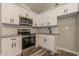 A well-lit kitchen featuring white cabinets and stainless appliances at 313 Linda Dr, Tucker, GA 30084