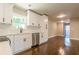 Updated kitchen with stainless steel dishwasher, white cabinets, and dark hardwood floors flowing into dining area at 313 Linda Dr, Tucker, GA 30084