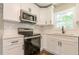 Modern kitchen showcasing white cabinetry, stainless steel microwave, and range with white subway tile backsplash at 313 Linda Dr, Tucker, GA 30084