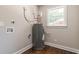 Utility room featuring water heater, window, hardwood floors, and updated electric and plumbing connections at 313 Linda Dr, Tucker, GA 30084