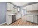 Renovated kitchen featuring white cabinets, stainless steel appliances, and new hardwood flooring at 3875 Wisteria Lane Southwest Sw Ln, Atlanta, GA 30331