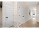 Hallway view with white doors and black hardware leading to the staircase and the outside area at 735 Shetland Trl, Cartersville, GA 30121