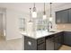 Beautiful kitchen island with a sink and faucet, featuring modern pendant lights and a view to the backyard at 735 Shetland Trl, Cartersville, GA 30121