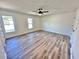 This bedroom offers a ceiling fan, new wood flooring, and two large windows at 101 Summer Pond Trl, Lawrenceville, GA 30046