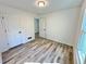 This bedroom features new wood flooring, a large window, and white paint at 101 Summer Pond Trl, Lawrenceville, GA 30046