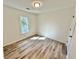This bedroom features new wood flooring, a large window, and a light-colored paint at 101 Summer Pond Trl, Lawrenceville, GA 30046