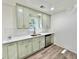 Charming kitchen features light green cabinets, stainless steel appliances and bright white countertop at 101 Summer Pond Trl, Lawrenceville, GA 30046