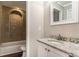 Bathroom with a granite vanity, wood-look floors, and tiled shower with built-in alcove for storage at 1743 Thomas Ter, Decatur, GA 30032