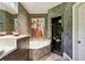 Bathroom featuring dark cabinets and a bathtub next to glass door shower at 857 Stovall Ne Pl, Atlanta, GA 30342