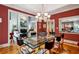 A modern dining room with a glass table, colorful chairs, and a view into the living room at 857 Stovall Ne Pl, Atlanta, GA 30342