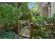 Landscaped garden with mature trees, ornamental iron gate and brick walls offering a private outdoor space at 857 Stovall Ne Pl, Atlanta, GA 30342