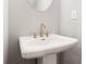Close up view of a pedestal sink with modern fixtures and a mirror in a well lit bathroom at 1330 Parc Bench Rd, Atlanta, GA 30316