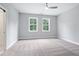 A spacious bedroom with neutral carpet, light gray walls, a ceiling fan and two windows at 1330 Parc Bench Rd, Atlanta, GA 30316
