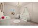 Bedroom with soft pink walls, elegant chandelier, crib with canopy, and comfortable rocking chair at 1590 Branthaven Ln, Auburn, GA 30011