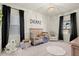 bedroom features natural wood crib, black out drapes and plush seating area at 1590 Branthaven Ln, Auburn, GA 30011
