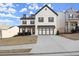 Beautiful two-story home with a black roof, white brick, and inviting front porch at 1590 Branthaven Ln, Auburn, GA 30011
