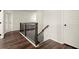 Hallway with wood floors and dark wood and metal railing with white trim at 1590 Branthaven Ln, Auburn, GA 30011