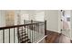 Upstairs hallway showcases hardwood floors, dark wood railings and an abundance of natural light at 1590 Branthaven Ln, Auburn, GA 30011
