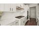 Close-up of a white kitchen with stainless steel appliances and dark hardware accents at 1590 Branthaven Ln, Auburn, GA 30011