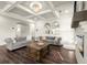 Open living room features hardwood floors, stylish furniture, and modern fireplace with a coffered ceiling at 1590 Branthaven Ln, Auburn, GA 30011
