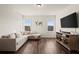 Bright living room features hardwood floors, neutral paint, and a large TV and lots of natural light at 1590 Branthaven Ln, Auburn, GA 30011