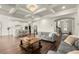 Open concept living room and kitchen with hardwood floors, coffered ceilings, and modern stainless appliances at 1590 Branthaven Ln, Auburn, GA 30011