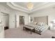 Main bedroom with tray ceiling, chandelier, large bed, and en suite bathroom access at 1590 Branthaven Ln, Auburn, GA 30011