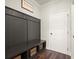 Mudroom features custom built-in storage with coat hooks, bench and storage shelves below, next to white paneled door at 1590 Branthaven Ln, Auburn, GA 30011