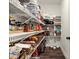 Walk-in pantry with white wire shelving, dark wood floors, and an assortment of food items and small appliances at 1590 Branthaven Ln, Auburn, GA 30011