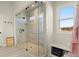 Large glass-enclosed shower with bench, featuring neutral tile and black hardware, bright window and storage at 1590 Branthaven Ln, Auburn, GA 30011