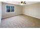 Carpeted bedroom featuring a ceiling fan, natural light, and ample space at 25 Cloud Forest Ct, Stockbridge, GA 30281