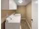 Functional laundry room with washer, dryer, and overhead cabinets for storage at 25 Cloud Forest Ct, Stockbridge, GA 30281