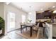 Well-lit dining area with a table set for six next to a kitchen with dark cabinets at 1390 Napa Valley Sw Dr, Lawrenceville, GA 30045