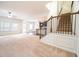 Bright living room features neutral carpet, a ceiling fan, and a view into the kitchen at 1390 Napa Valley Sw Dr, Lawrenceville, GA 30045